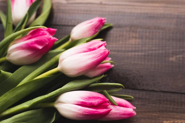 Kopya alanı ile ahşap koyu arka plan üzerinde Taze güzel pembe laleler