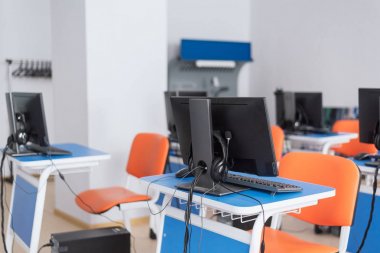 parlak mavi masalar ve turuncu sandalyeler ile boş bilgisayar sınıfı. çocuklara programlama yı öğretmek