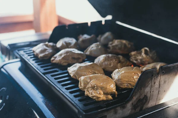 Gegrilltes Hühnchen beim Picknick. Der Mann legte das Huhn zur Zubereitung in die Marinade auf den Grill. Ganze große Hühnerkadaver stehen in Flammen. Draußen kochen. — Stockfoto