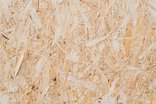 Pressed sawdust in the board. Wooden textured background. background of pressed beige wooden sawdust. — Stock Photo, Image