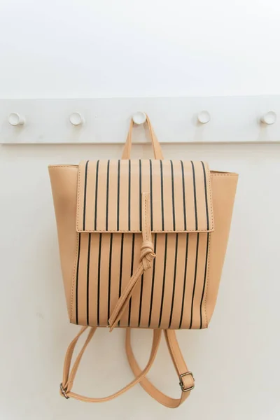 Beiger Rucksack auf einem Kleiderbügel im Schrank. Ein Rucksack hängt an einem Haken in einer Umkleidekabine. — Stockfoto