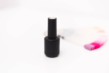 Beyaz arka planda, uçlarının yanında siyah bir kavanozda sarı oje. Etiketlerin renk kalıplarının yanında jel oje..