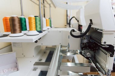 dikiş makinesi üzerinde renkli iplik. kumaş üzerinde endüstriyel kabartma metin. endüstriyel dikiş makinesi üzerinde birçok dikiş.