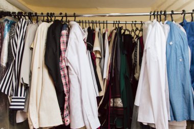 Dolaptaki bir rafta bir sürü kıyafet var. bir konfeksiyon fabrikasında giyim.