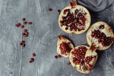 Gri bir grunge beton arka plan üzerinde birkaç olgun nar. Büyük kırmızı tanecikli el bombaları beton kaldırımda yatıyor.