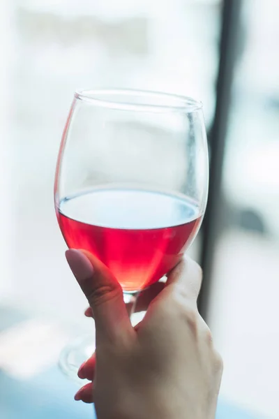 Uma menina com uma manicure nua suave segurando um copo de cerveja espumosa de cereja . — Fotografia de Stock