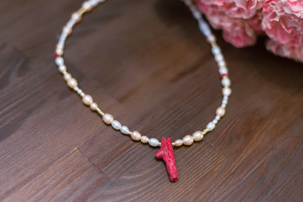 Necklace made from freshwater pearls and red coral. Trendy, stylish and fashionable luxury level decoration on a wooden table — Stock Photo, Image
