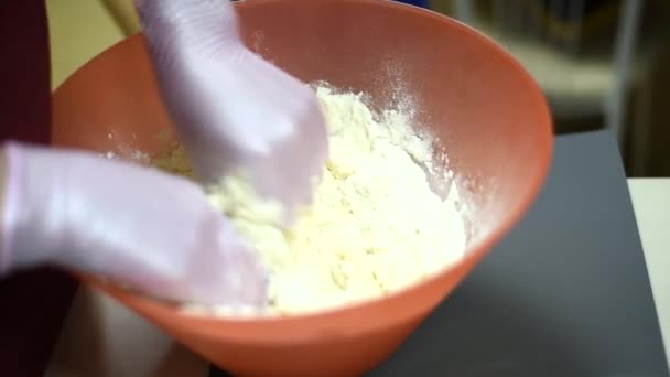 小麦粉とバターから作られた女の子のこね生地 手袋の調理人は小麦粉が生地を作るのを防ぎます — ストック動画