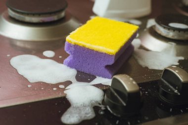 Menekşe - metal gaz sobası ile sarı sünger. Kiri köpüklü süngerle temizleme.