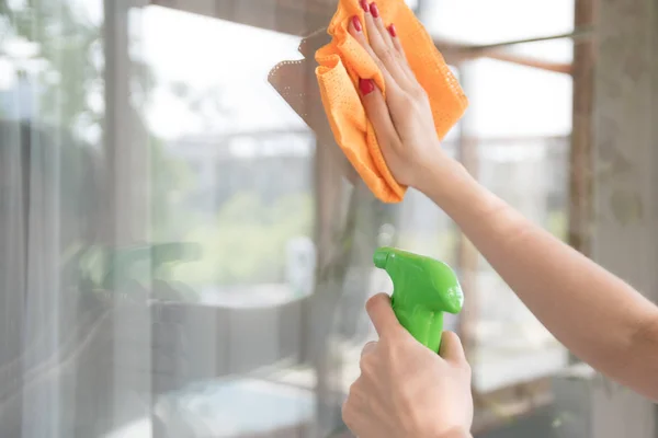 A cleaning company cleans the window of dirt. Housewife polishes a house window with a window cleaner