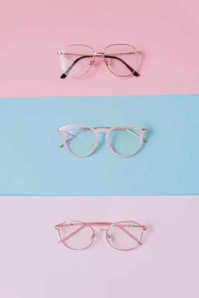 stylish image glasses on a pastel background. Three pairs of glasses with lenses on a pink and blue backgrounds. stylish and trend optics