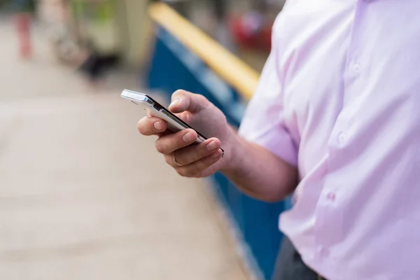 phone in the hands of a man on the street. dependence on mobile, social networks.