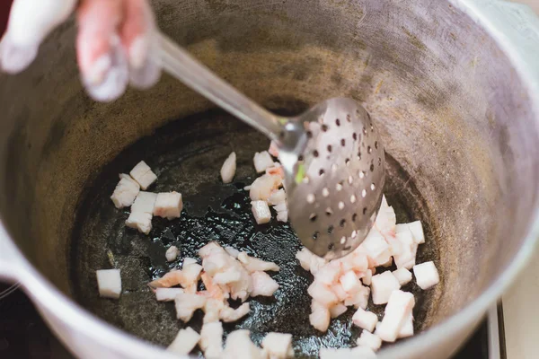 Fritando cauda gorda em um caldeirão no fogão. Aquecimento da banha — Fotografia de Stock