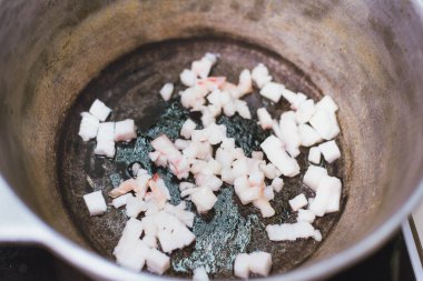 Sobaydaki bir kazanda yağ kuyruğunu kızartmak. Domuz yağı ısıtma