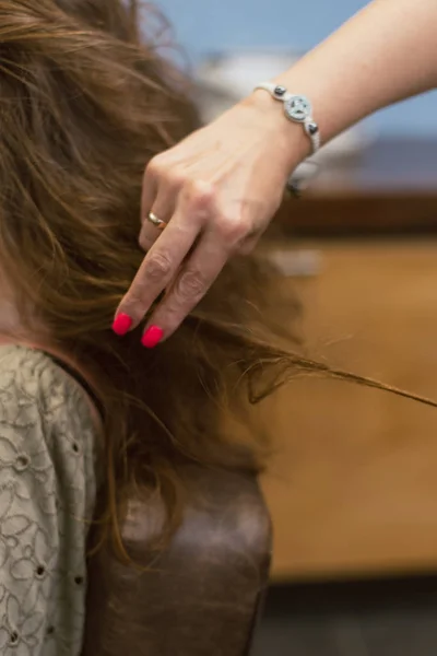 La creación de peinados en el cabello castaño oscuro en el salón. Crear rizos en la peluquería — Foto de Stock