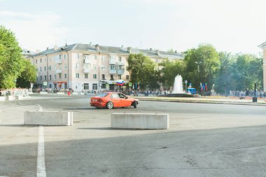 Samara Rusya - 07.05.19 Rusya Gençlik Günü. Meydandaki insanlar yollarda araba kayması gibi görünüyorlar. Kırmızı bir arabanın lastiklerinin altından duman