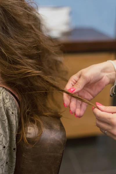 La creación de peinados en el cabello castaño oscuro en el salón. Crear rizos en la peluquería — Foto de Stock