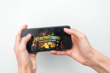 Samara, Rusya -07, 29, 2019: Genç bir adam Iphone 8 Plus'ta Hearthstone oyunu oynuyor. Genç çocuk beyaz bir arka plan üzerinde bir oyun Hearth Stone ile elinde bir telefon tutarak