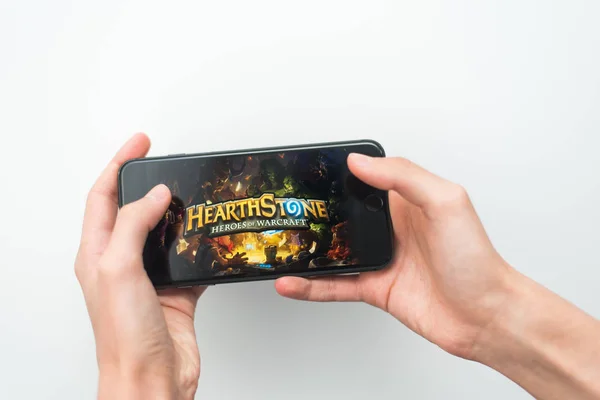 Samara, Russia -07, 29, 2019: A young guy plays a HearthStone game on Iphone 8 Plus. Teenage boy holding a phone in his hands with a game Hearth Stone on a white background — Stock Photo, Image