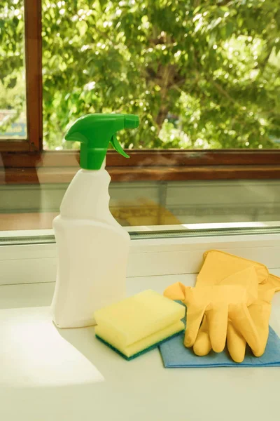 Миючий засіб, губка, рукавички на фоні вікна. Інструменти для чищення вікон — стокове фото