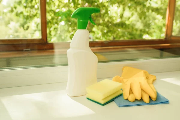 Миючий засіб, губка, рукавички на фоні вікна. Інструменти для чищення вікон — стокове фото