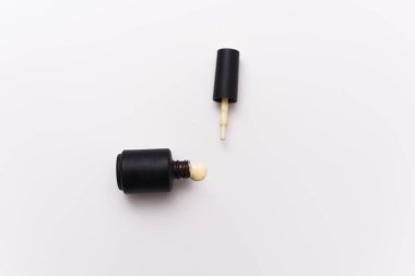 beyaz bir arka plan üzerinde siyah bir şişe sarı jel oje. Bloglar ve tasarım şablonları için Manikür kavramı