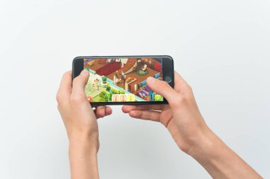 Samara, Rusya -07, 29, 2019: Iphone 8 Plus'ta Homescapes oyunu oynayan genç bir adam. Genç çocuk beyaz bir arka plan üzerinde bir oyun Ev scapes elinde bir telefon tutarak.