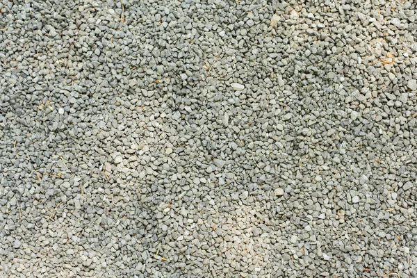 En hel del små stenar ligger på en stig i parken. Förbereder vägen för utjämning. Sten bakgrund — Stockfoto