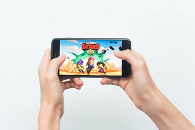 Samara, Rusya -07, 29, 2019: Iphone 8 Plus'ta brawl stars oyunu oynayan genç bir adam. Genç çocuk beyaz bir arka plan üzerinde bir oyun Brawl Stars ile elinde bir telefon tutarak