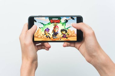 Samara, Rusya -07, 29, 2019: Iphone 8 Plus'ta brawl stars oyunu oynayan genç bir adam. Genç çocuk beyaz bir arka plan üzerinde bir oyun Brawl Stars ile elinde bir telefon tutarak