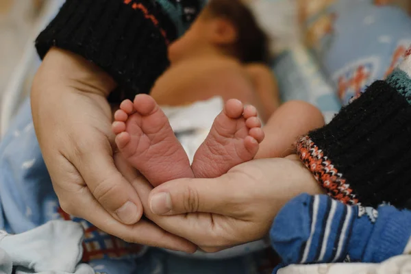 Füße eines neugeborenen Babys in den Händen der Eltern. das Konzept von Liebe, gesunder Geburt und glücklichen jungen Eltern. — Stockfoto