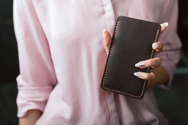 Una funda de cuero para el teléfono en la mano de la chica — Foto de Stock