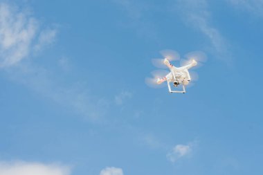 mavi gökyüzüne karşı drone. quadcopter yukarıdan arsa vuruyor. Uzak quadrocopter mavi gökyüzünde uçar