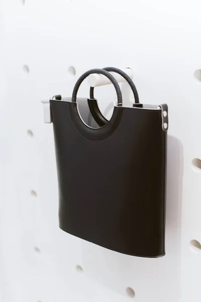 Borsa classica in pelle nera con manici rotondi su uno scaffale in un negozio. Elegante borsa da donna casual — Foto Stock