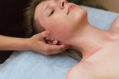 masör genç bir adamın boynuna masaj yapıyor. tıbbi masaj ile boyun ve omurga da ağrı tedavisi.