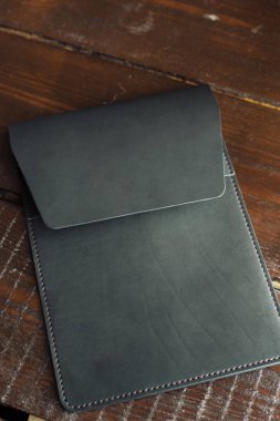 Tablet için siyah deri çanta. Ahşap bir arka planda eko deri çanta.