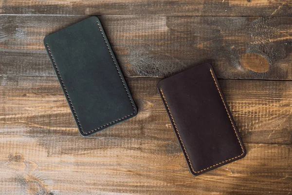 leather luxury phone cases on a wooden background. Beautiful genuine leather phone cases