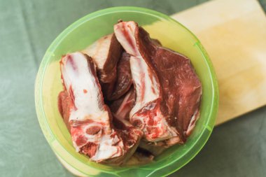plastik bir kapta kemik üzerinde et. yemek pişirmek için taze et.
