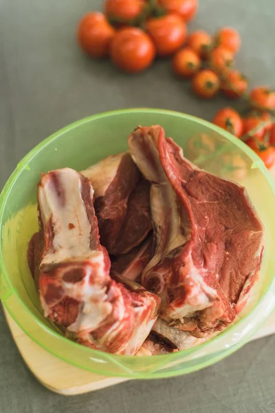 Viande sur l'os dans un récipient en plastique. viande fraîche pour la cuisson . — Photo