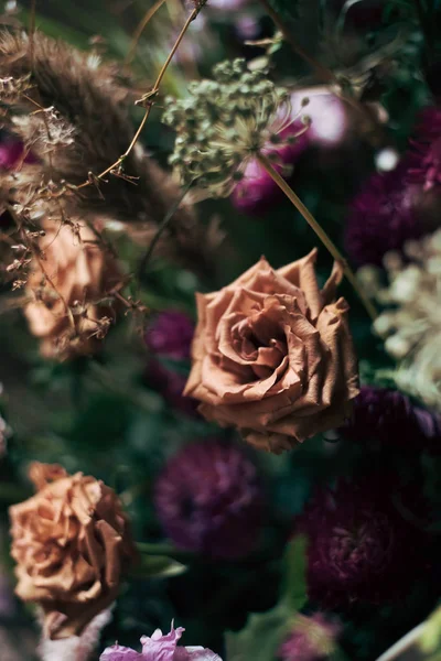 dried rose in a bouquet with field grass. delicate dried flowers