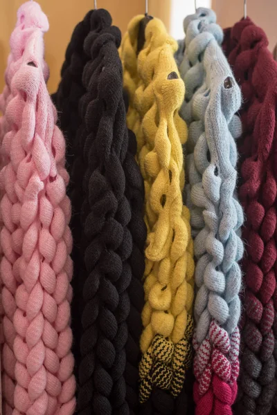 編んだセーターとカーディガンが床のハンガーにかかってるワードローブの色の大きなニットウェア. — ストック写真