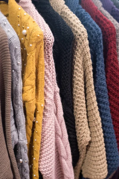 Camisolas de malha e cardigans pendurar em um cabide. Malhas grandes coloridas no guarda-roupa . — Fotografia de Stock