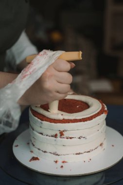 pudra kek üzerine krema sıkar. Kız bir kek yapmak