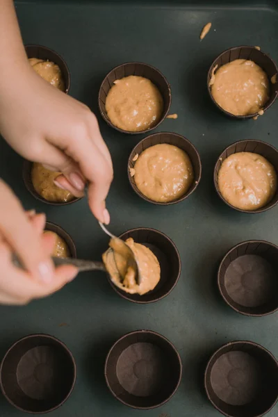 El panadero crea cupcakes en moldes. El panadero crea magdalenas de zanahoria — Foto de Stock