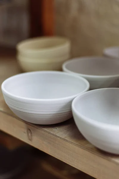 Gray handmade ceramic plates. Glazed clay plates in a pottery workshop.