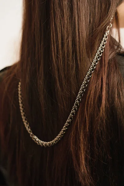 Cadena pesada en los puntos de metal en el pelo oscuro de una joven. Cadena de gafas de metal con estilo — Foto de Stock