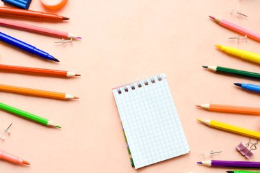 Parlak kırtasiye malzemesi, pembe arka planda not defteri. Okula dönmek, çalışma alanı kavramı. Üst görünüm, düz görünüm, kopyalama alanı, maket.