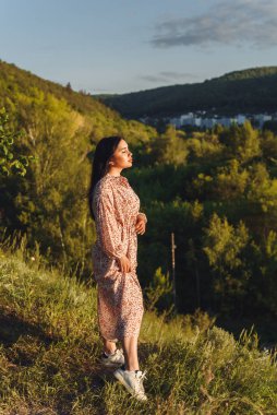 Kız tepenin üstünde. Yeşiller içindeki çekici esmer. Gizemli kız uzaklara bakıyor..
