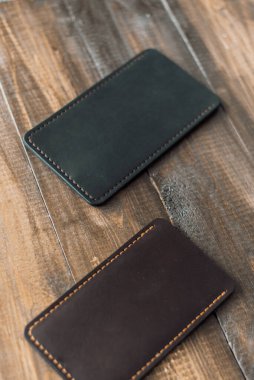 Ahşap arka planda deri, lüks telefon kılıfları. Güzel, hakiki deri telefon kılıfları..