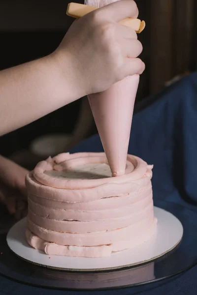 Las Manos Una Chica Panadera Aprietan Crema Rosa Sobre Una — Foto de Stock